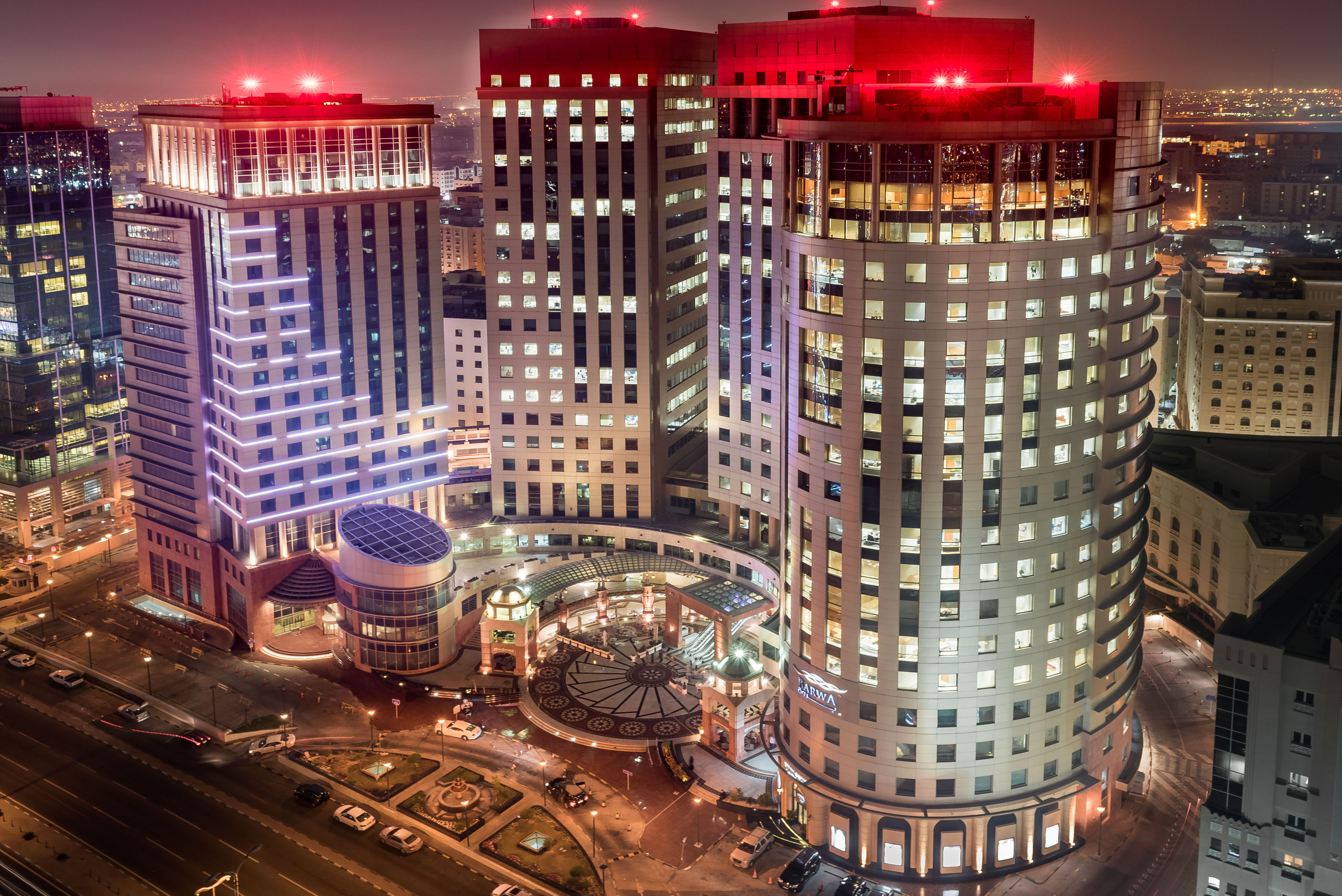 Barwa Real Estate — aerial view of our integrated urban development, modern high-rises and central plaza at night